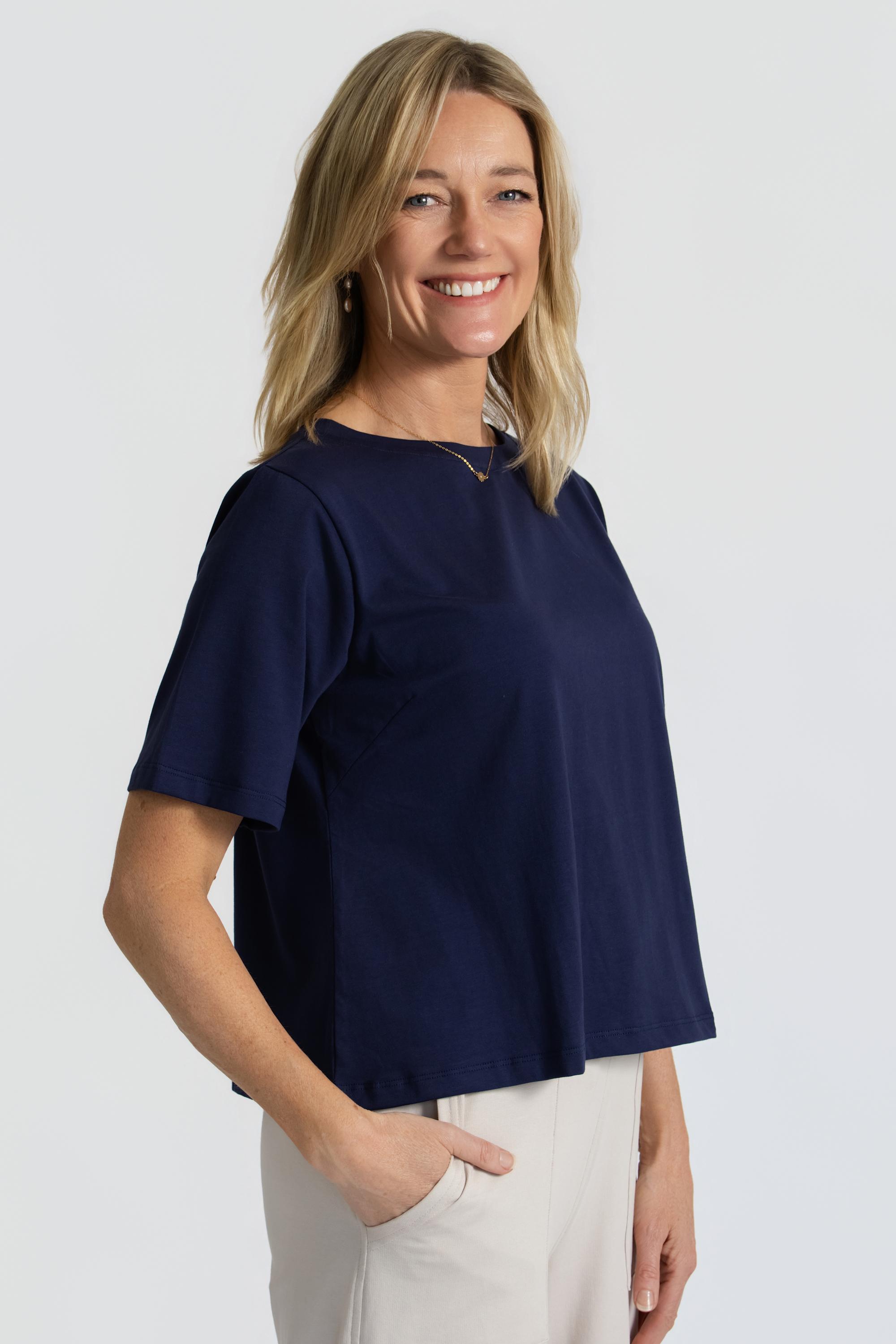 Woman wearing a ink tee against a plain background