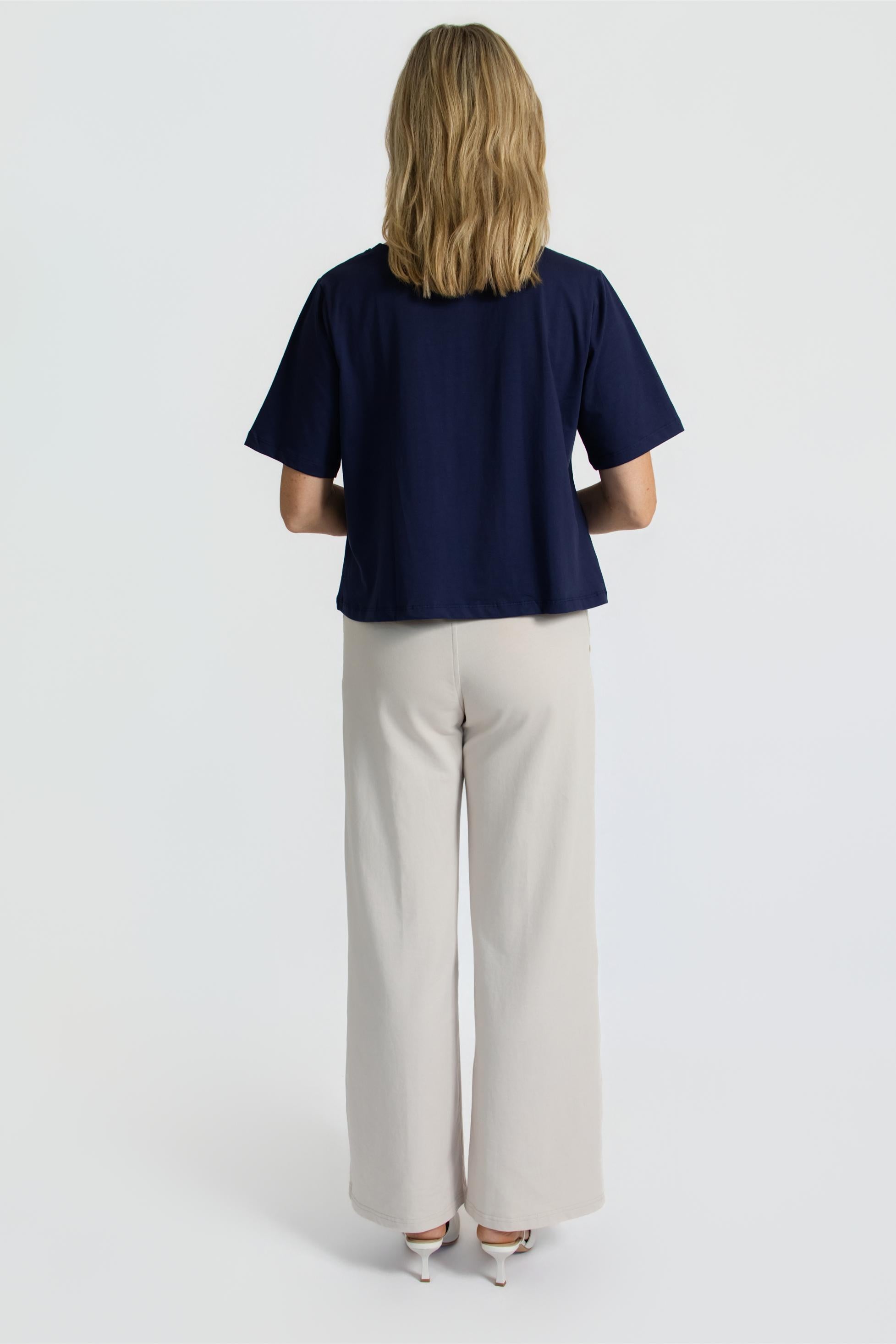 Person wearing a organic ink tee and oatmeal wide-leg pants on a white background