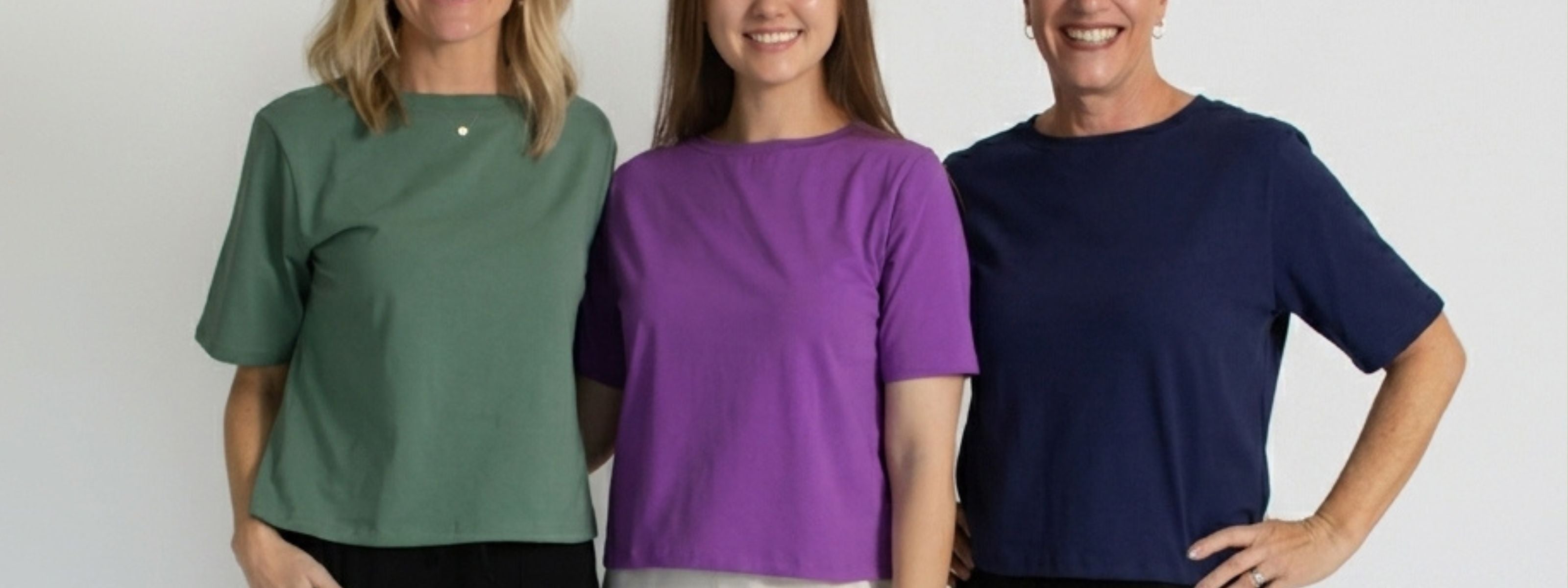 Models wearing Agave, purple, and teal shirts with black pants on a white background