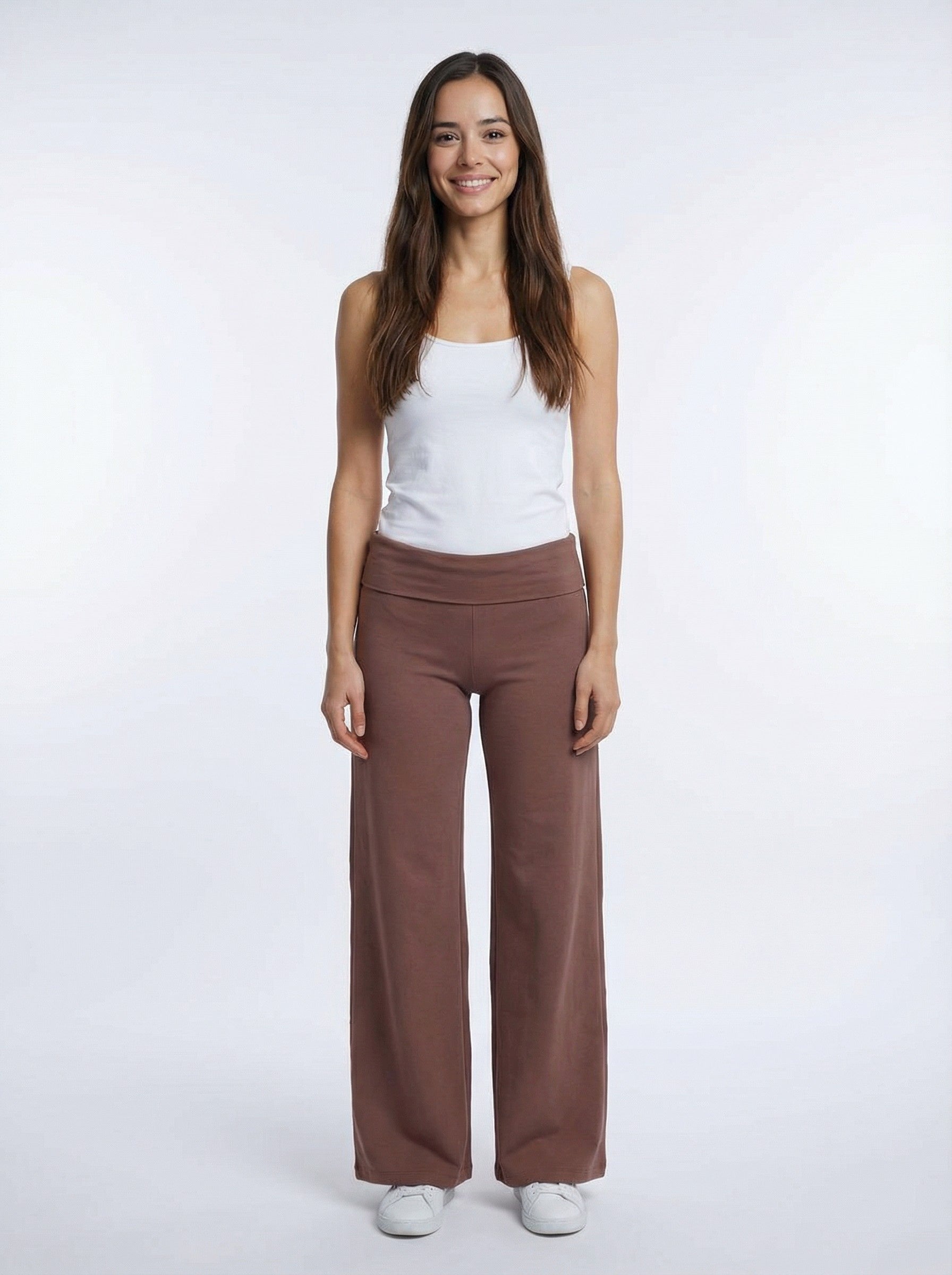 Woman wearing a white tank top and organic cotton Leisure Lux Pants - Mocha Mousse on a white background