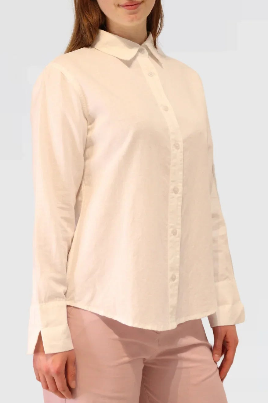 Woman wearing a white linen blouse against a white background