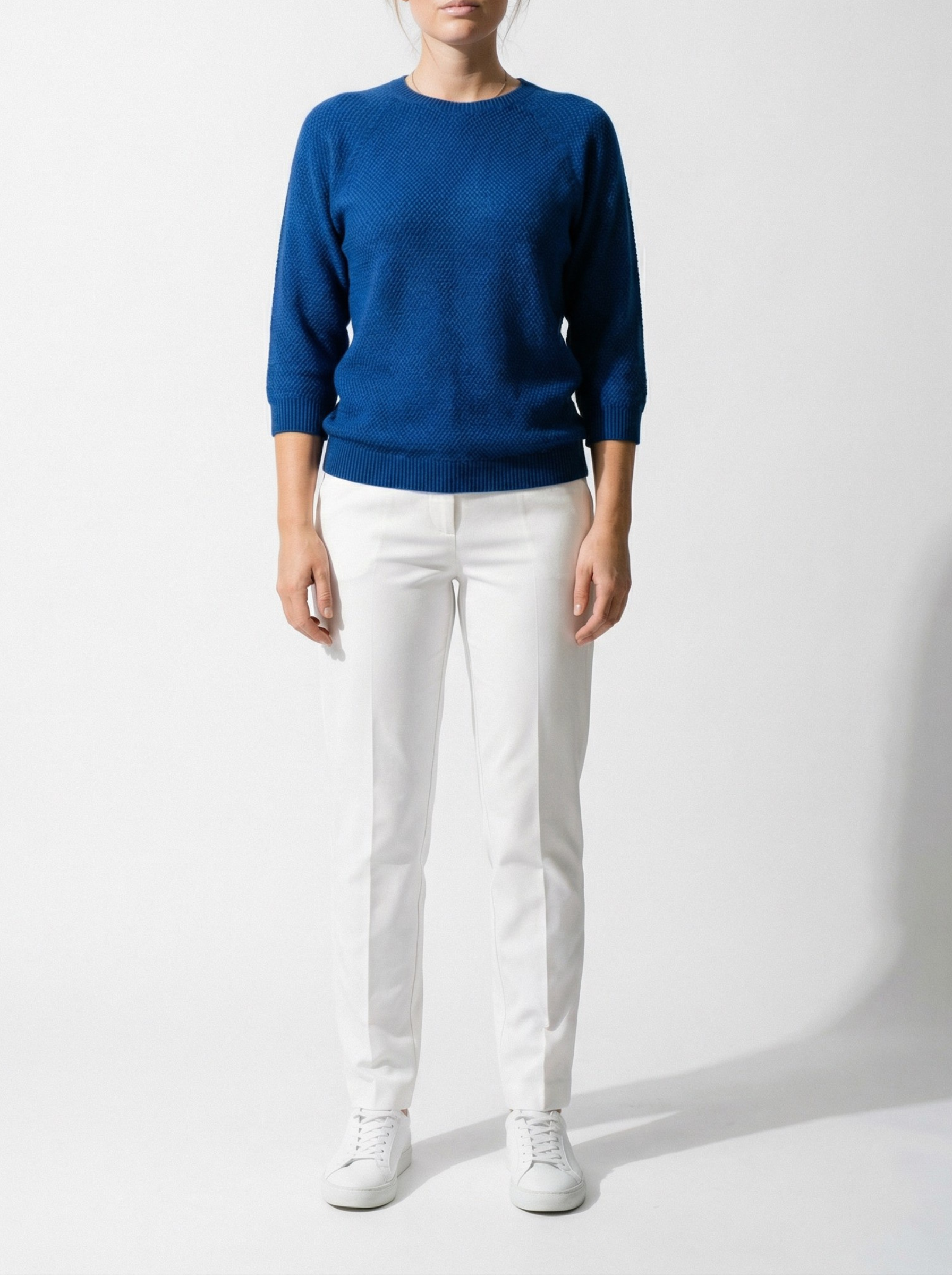 Person wearing a Penny Textured Jumper - Cobalt and white pants on a white background