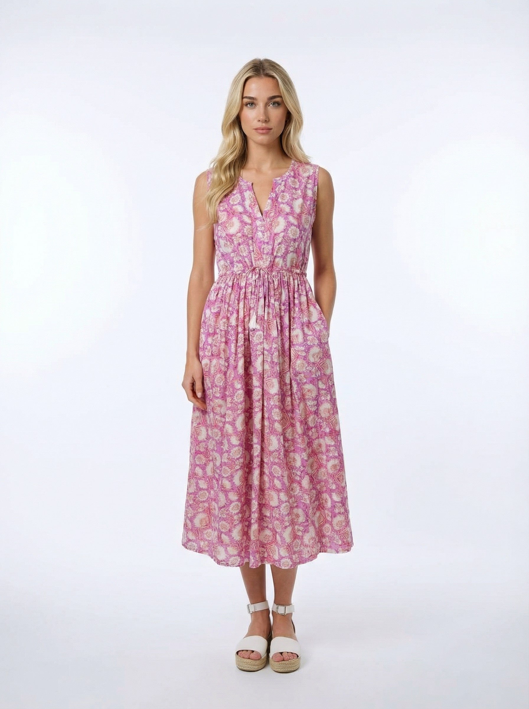 Woman wearing a Pink Magnolia Cotton floral dress on a white background