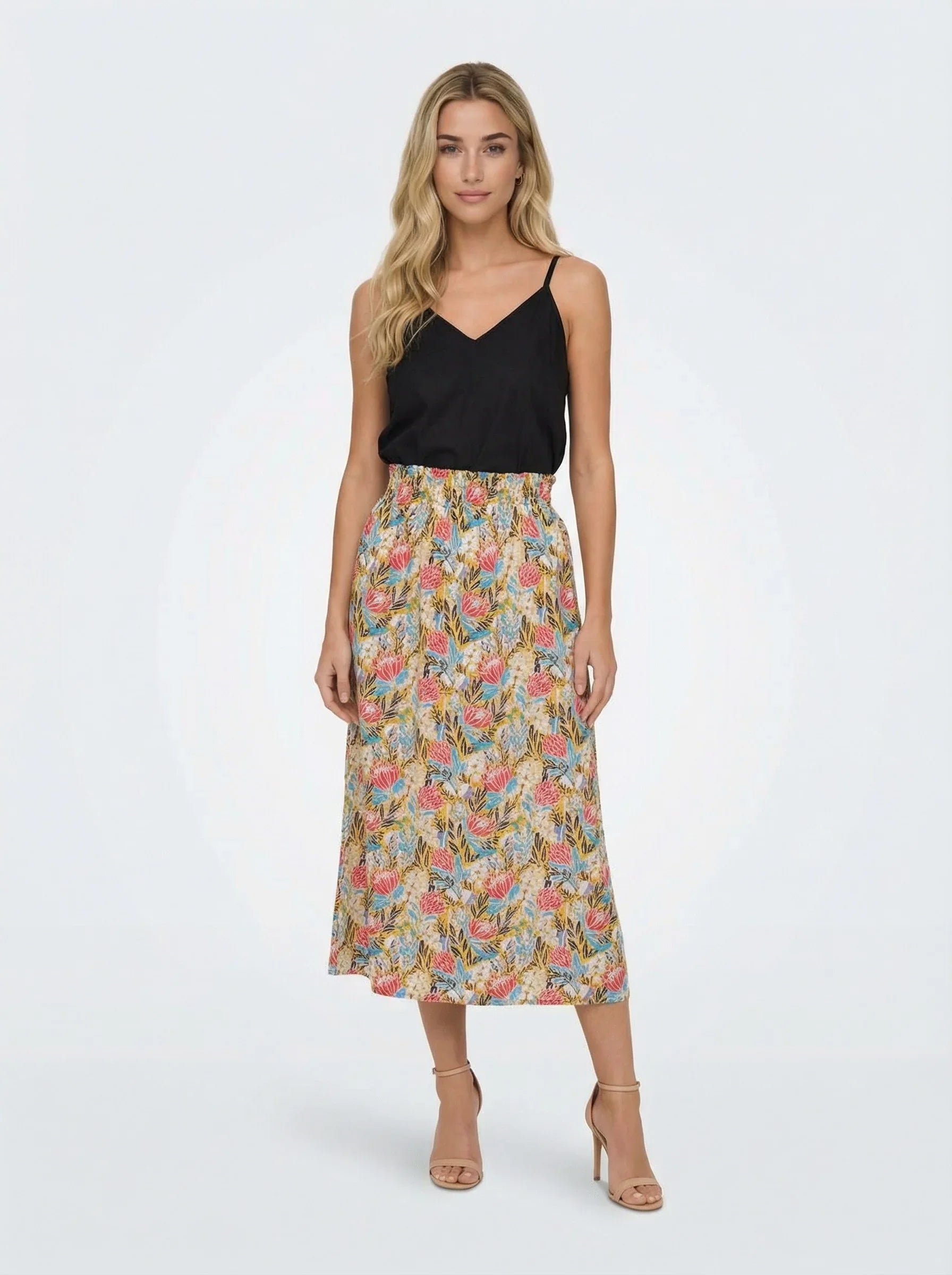 Woman wearing a black top and Protea Bloom Skirt on a white background