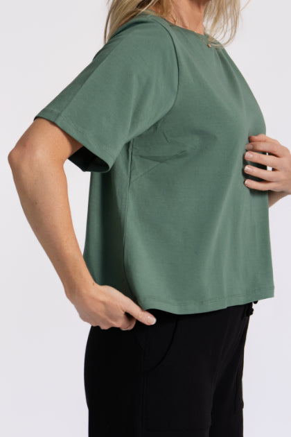 Model showing the side detail of the organic flex crew tee in Agave