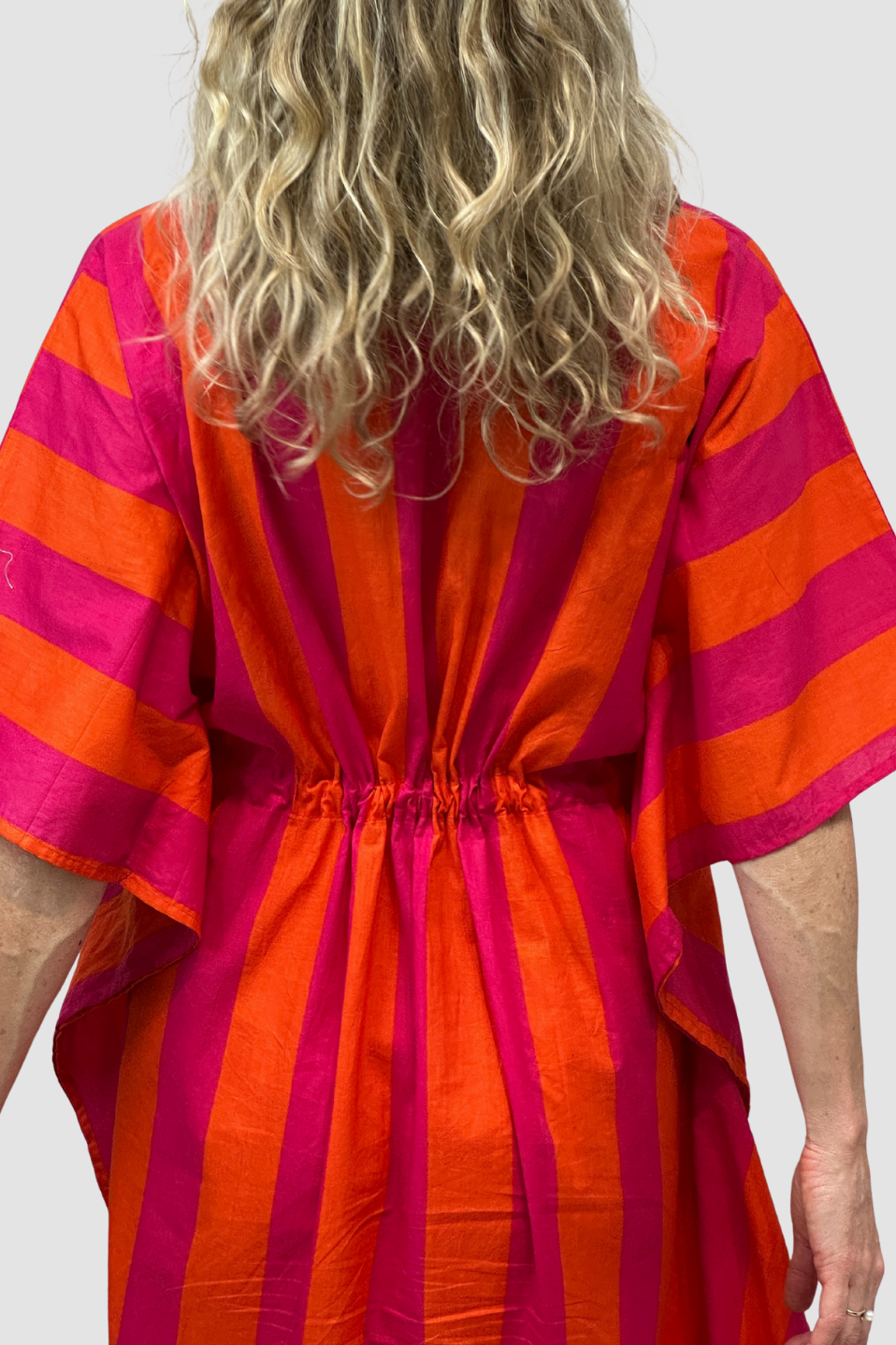 Person wearing a Sunset Stripe Pink & Orange Kaftan against a white background