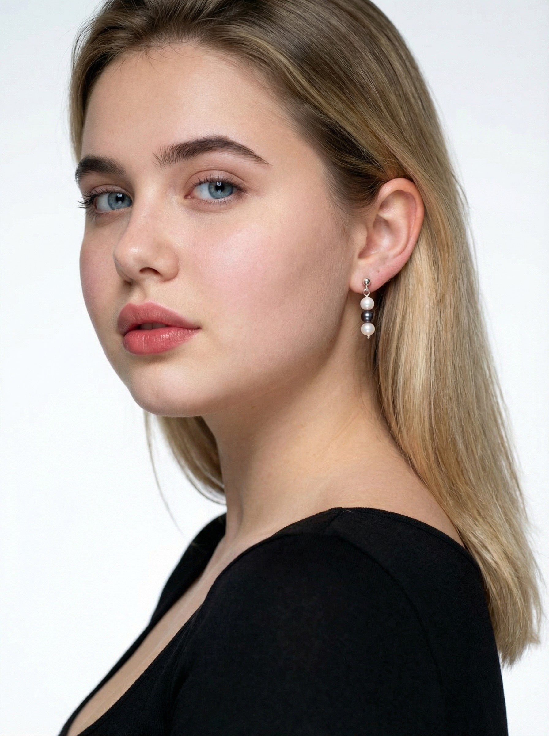 model in a black to is wearing Triple Pearl Drop Earrings