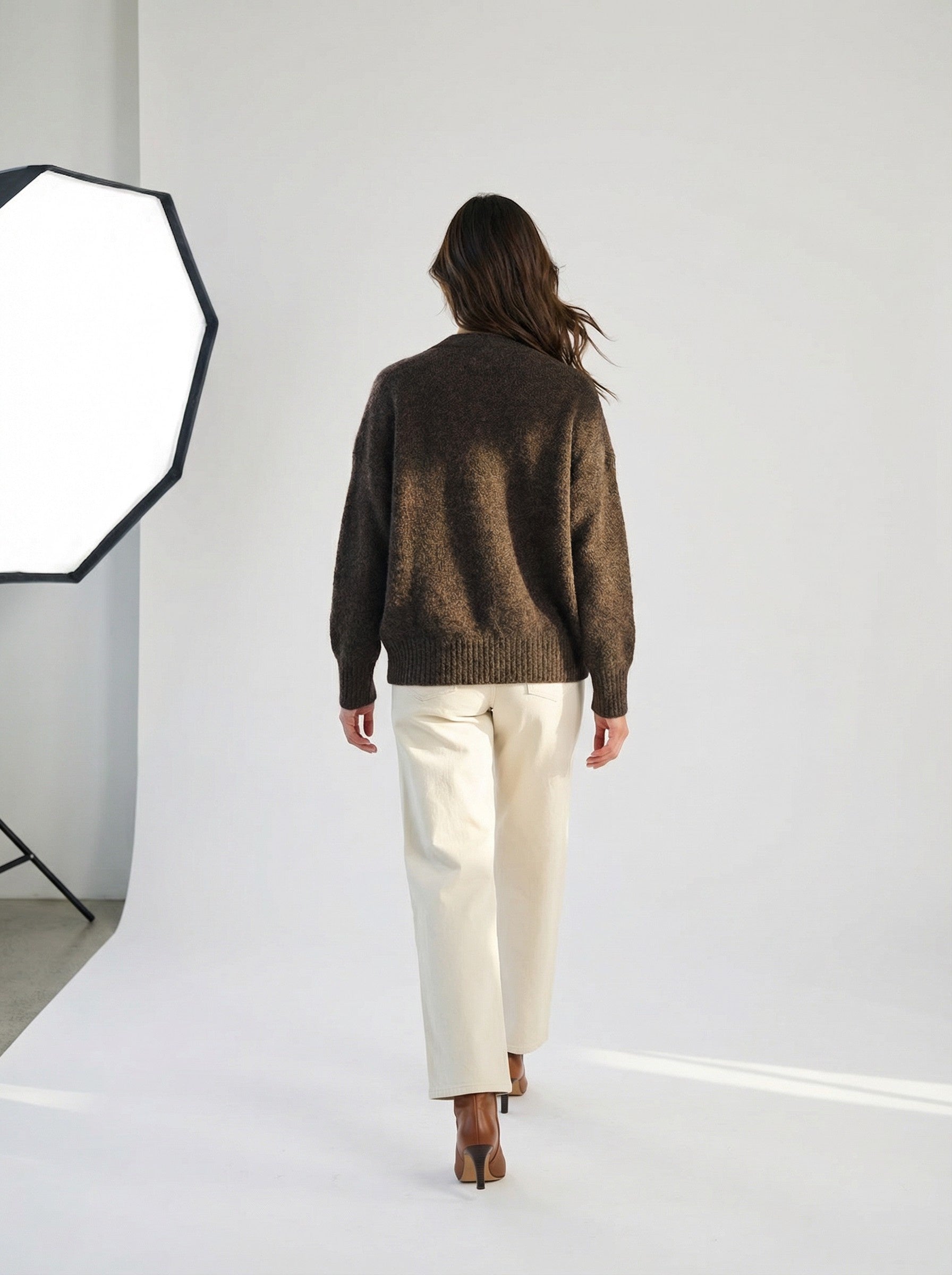 Person wearing a V-Neck Cardigan - Brown Marl and white pants standing in front of a softbox light on a white background