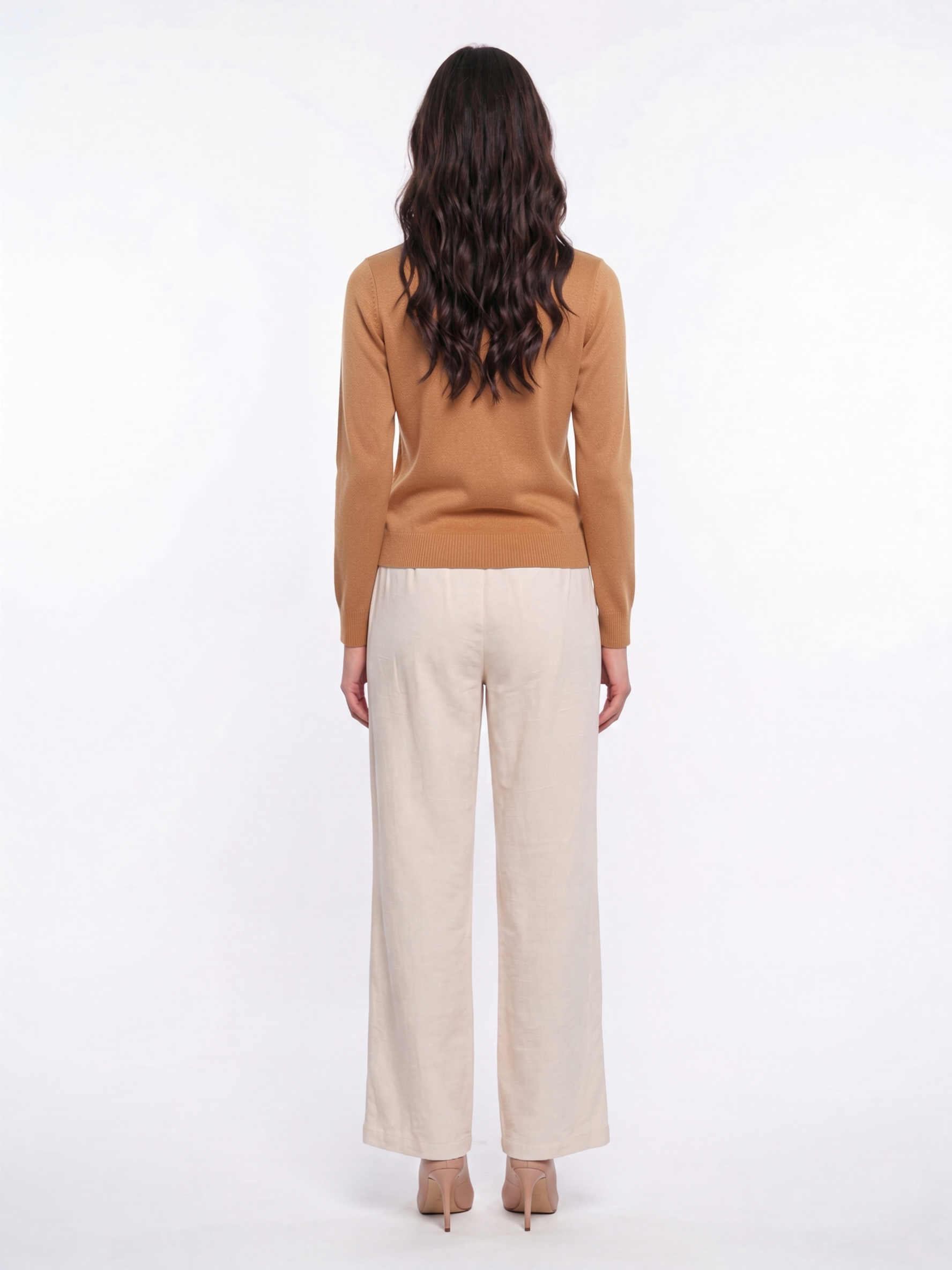 Back view of woman wearing a cinnamon tan Cashmere-Merino Cardigan with cream trousers
