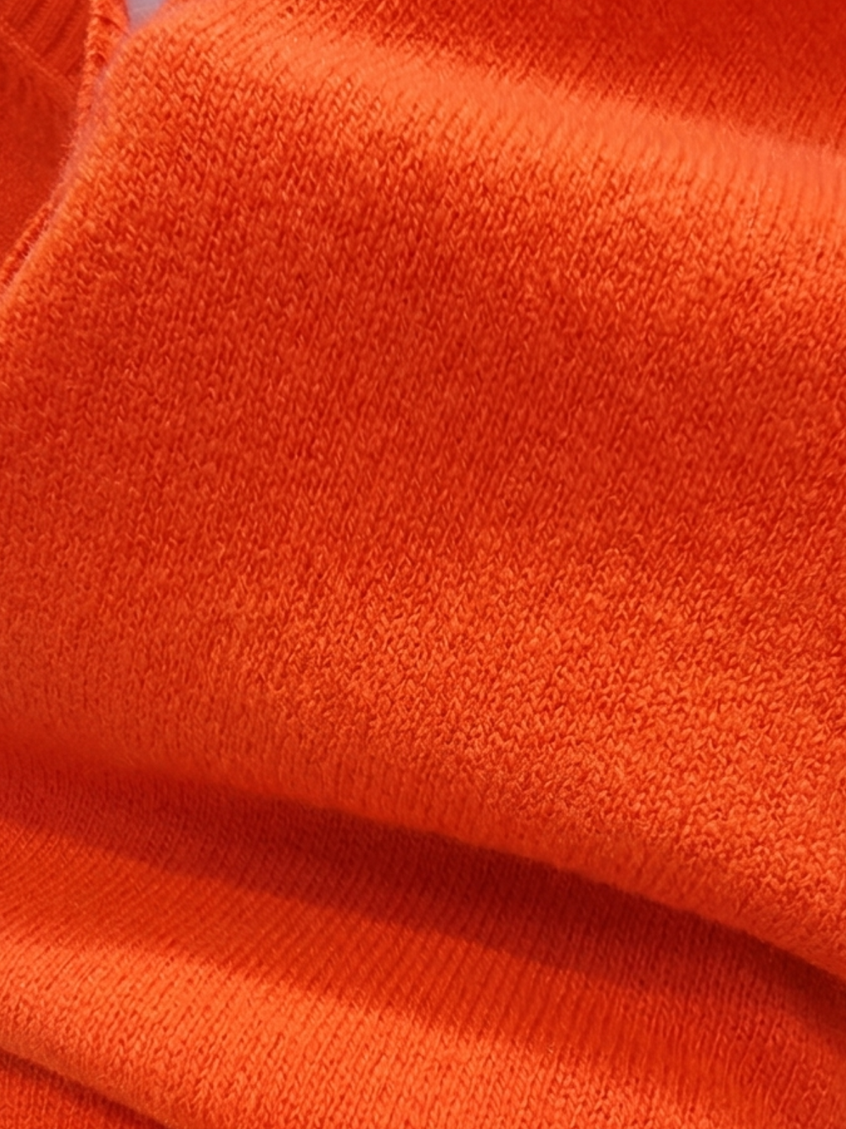 Close-up of scarlet red Cashmere-Merino Cardigan knit fabric showing soft texture and folds