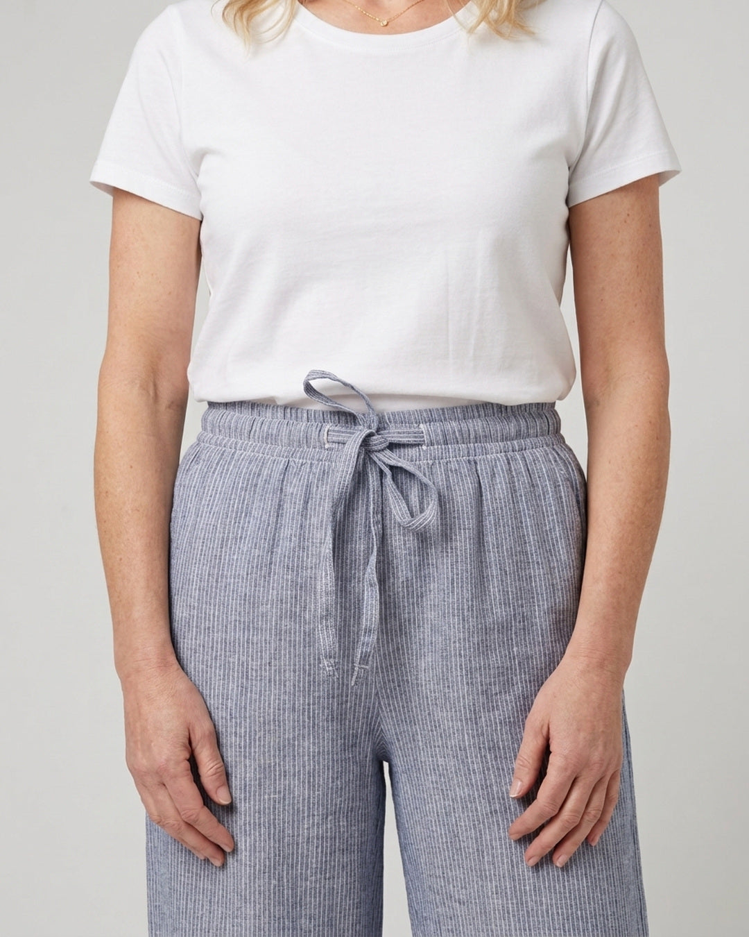 Front waist detail of the Cove Linen Cotton Pants showing the adjustable tie and fine blue stripe
