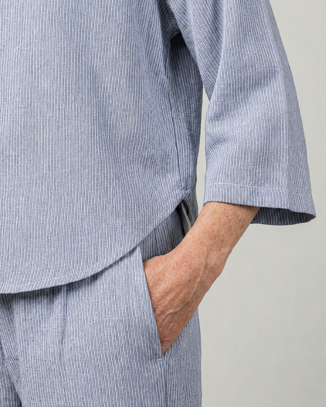 Side view of the Reca Cove Linen Crop Shirt worn with the matching Cove linen cotton pants, showing the cropped hem and three-quarter sleeve