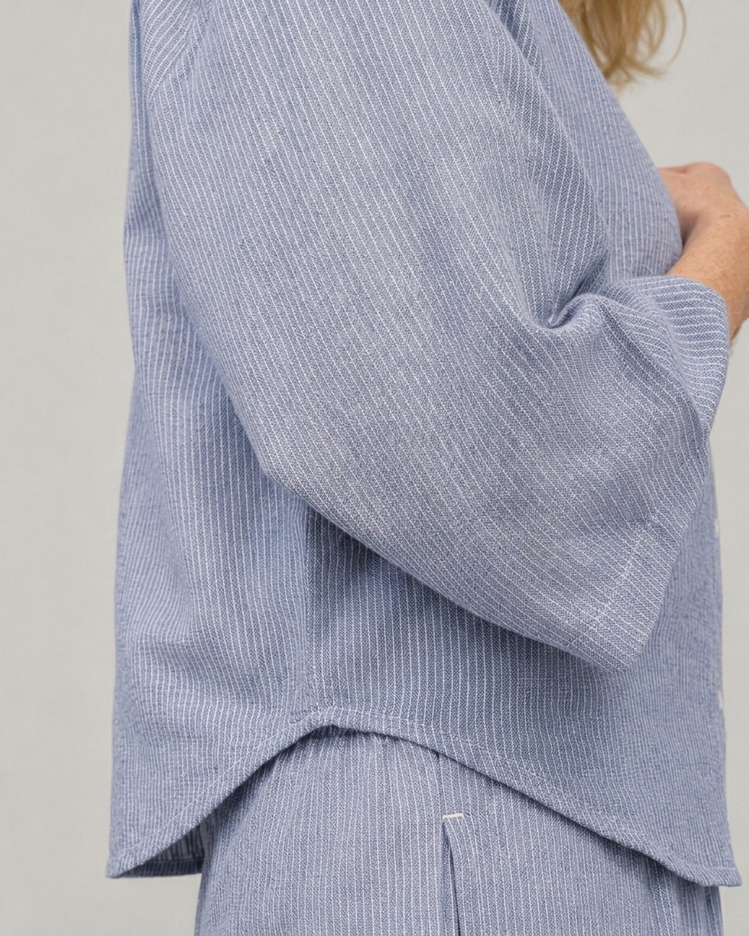 Detail of the wide three-quarter sleeve and cropped hem on the Cove Linen Crop Shirt in blue and white striped linen cotton