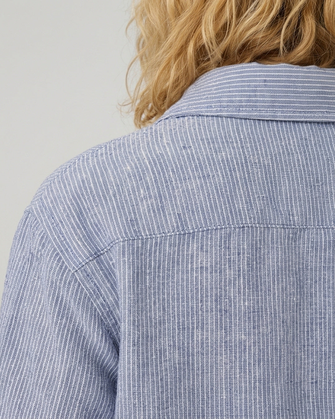 Close-up of the back yoke and shoulder seam on the Reca Cove Linen Crop Shirt in blue and white striped linen cotton