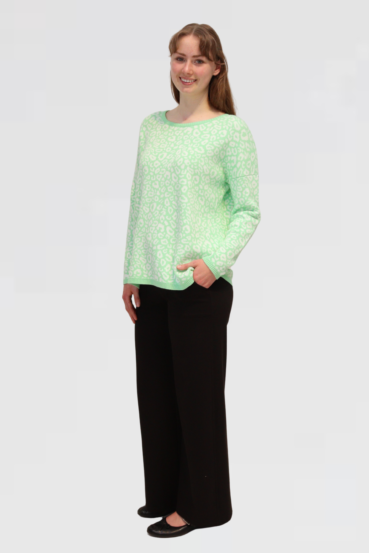 Woman wearing a Cotton Jacquard Sweater - Apple and black pants on a white background